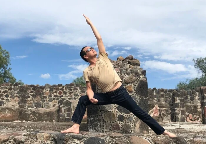 ext-side-angle Bene doing extended side angle warrior pose on stone wall
